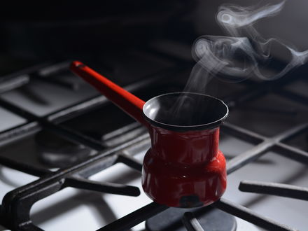 Обои на рабочий стол Турка с кофе на плите, над которой подымается пар, крупным планом