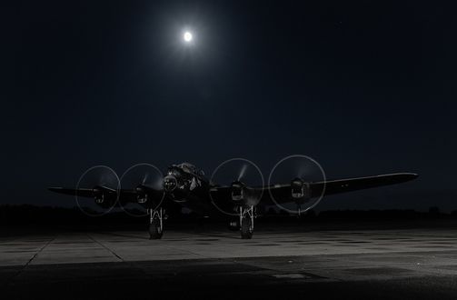 Обои на рабочий стол Британский бомбардировщик АВРО Ланкастер с работающими двигателями готовится стартовать с ночного аэродрома