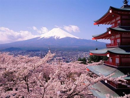 Обои на рабочий стол Japan, Fudzi / Цветущая вишня, фрагмент здания, на дальнем плане гора Фудзияма и, раскинувшийся у ее подножья город, на фоне неба