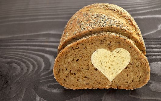 Обои на рабочий стол Злаковый батон, в который вставлен кусочек белого хлеба в виде сердца