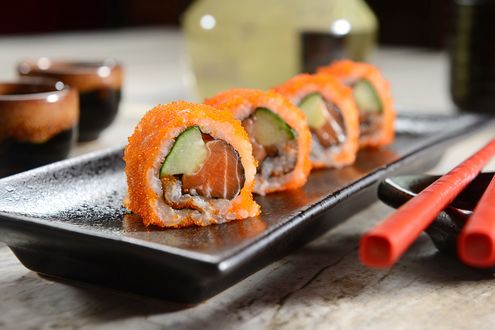 Обои на рабочий стол Японская кухня: роллы с рыбой и икрой на черной тарелке