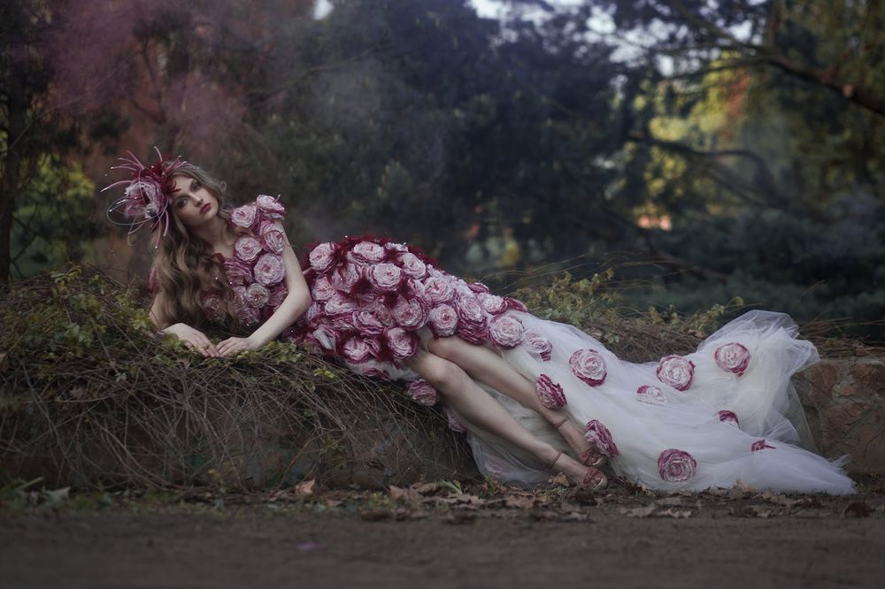 Обои для рабочего стола Красивая девушка в шикарном платье с розами и шляпке позирует на фоне природы