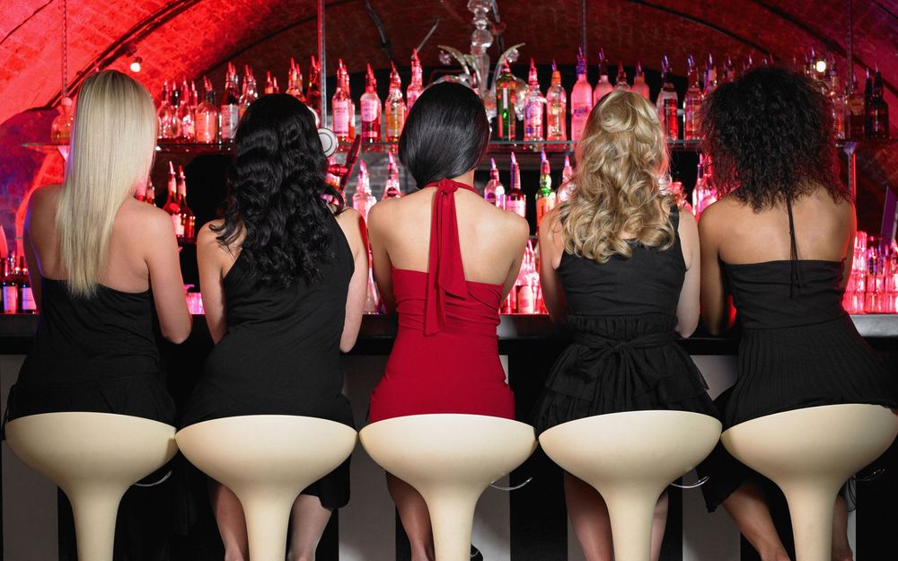 Обои для рабочего стола Пять девушек сидят спиной к зрителю и лицом к барной стойке