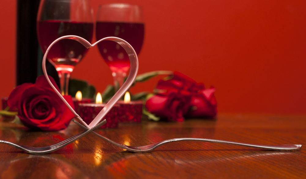 Обои для рабочего стола Стол, накрытый для двоих влюбленных: два бокала с вином, свечи и розы, две вилки и сердце