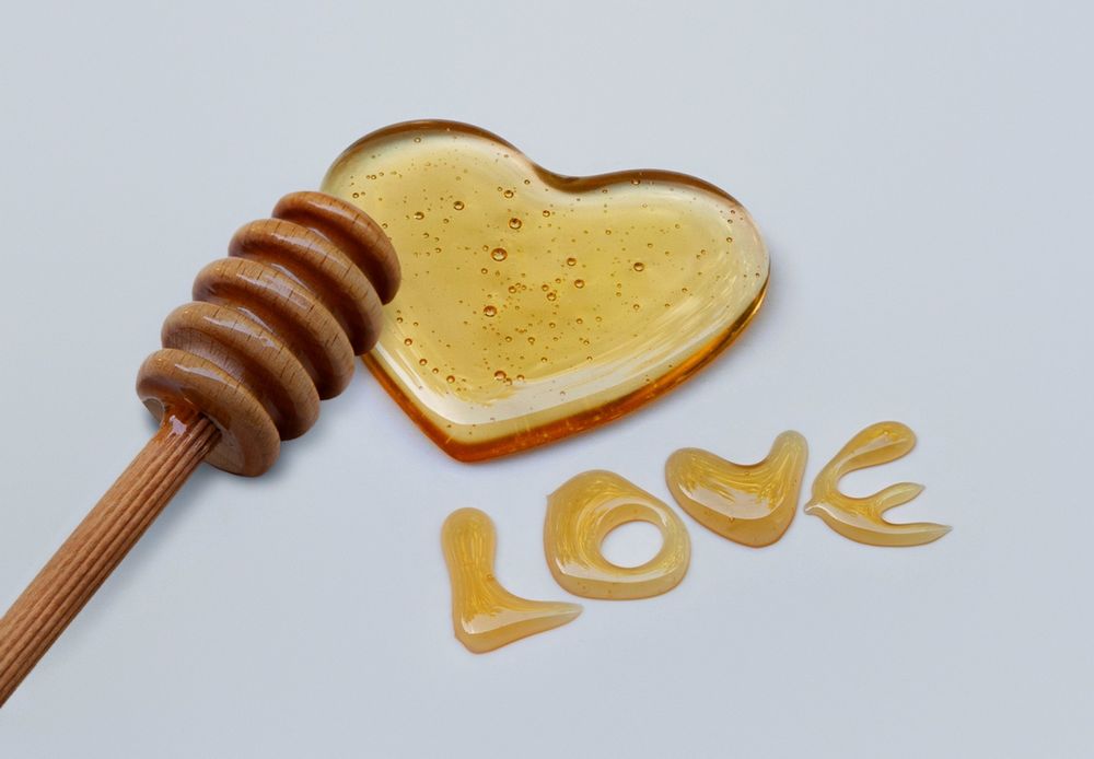 Обои для рабочего стола Медовое сердце и надпись Love / Любовь, а так же ложечка для меда