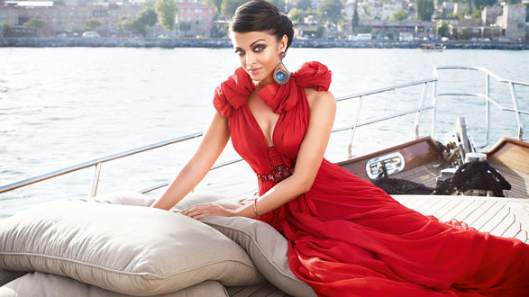 Обои на рабочий стол Индийская актриса Aishwarya Rai в красном платье позирует, сидя на палубе корабля