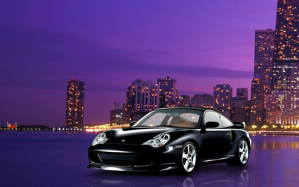 Обои для рабочего стола Черный Porsche / Порш на берегу залива, на фоне огней небоскребов ночного города