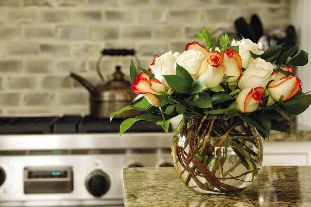Обои для рабочего стола Букет красивых роз в вазе стоит на столе