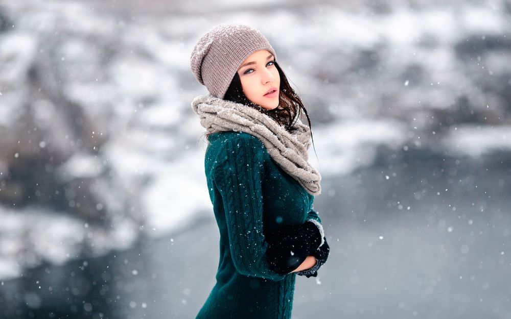 Обои для рабочего стола Модель Angelina Petrova / Ангелина Петрова в теплой одежде и шапочке позирует на фоне летящих снежинок