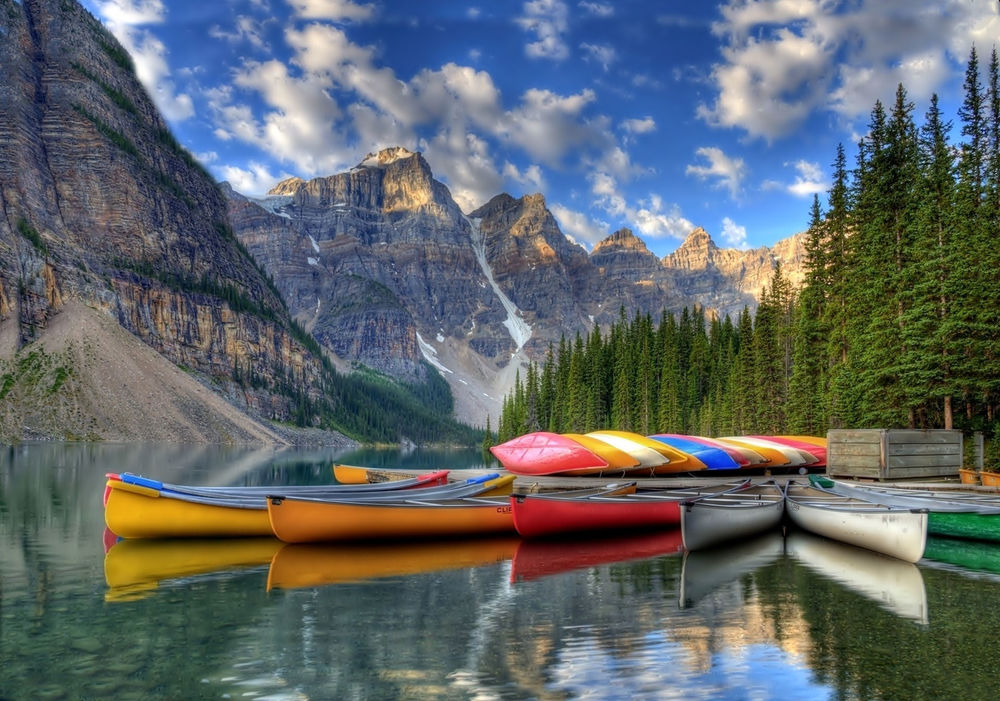 Обои для рабочего стола Разноцветные лодки на горном озере Rocky Mountain Lakes, Moraine Lake, Banff National Park, Canada / Морейн, Канада, на фоне неба, гор и леса