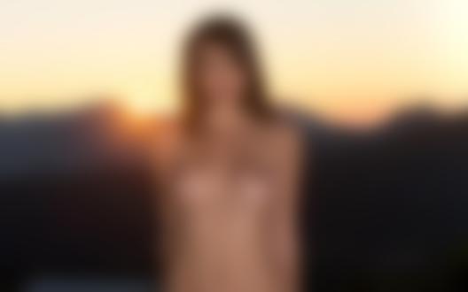 Обои для рабочего стола Малена Морган / Malena Morgan стоит обнаженная, на фоне заходящего солнца в горах