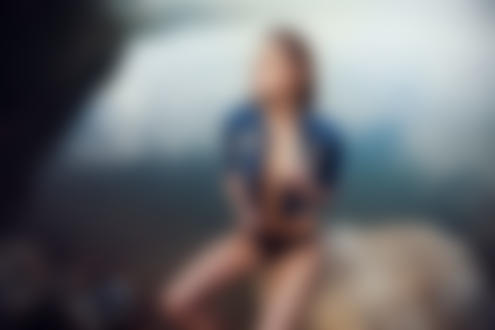 Обои на рабочий стол Девушка в растегнутой курточке сидит на камне у воды, фотограф Evgeniy Potanin