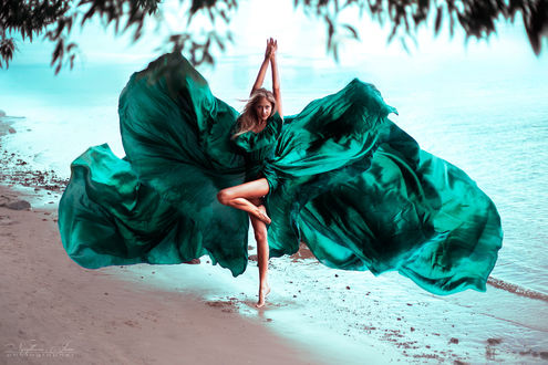 Девушка на пляже в развивающимся на ветру плье бесплатно