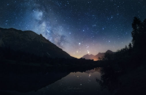 Обои на рабочий стол Работа Galactic Night / галактическая ночь, звездное небо над горами и отражение природы в озере, фотограф Michael Boehmlaender