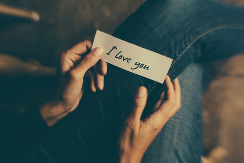 Обои на рабочий стол В руках парня записка с надписью i love you / я люблю тебя