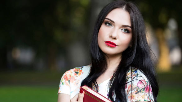 Обои на рабочий стол Темноволосая девушка держит в руках книгу