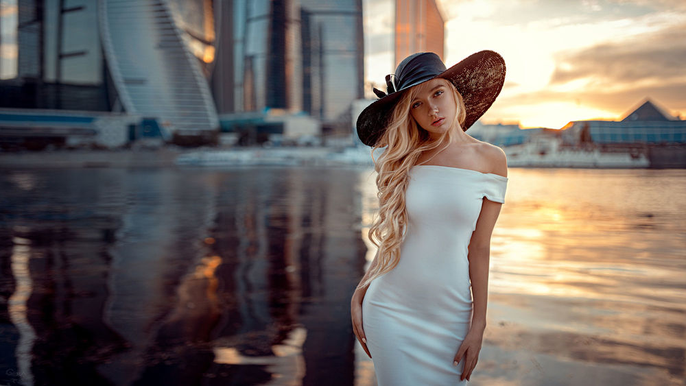 Обои для рабочего стола Модель Мари в белом платье и черной шляпе, стоит на фоне города, фотограф Георгий Чернядьев