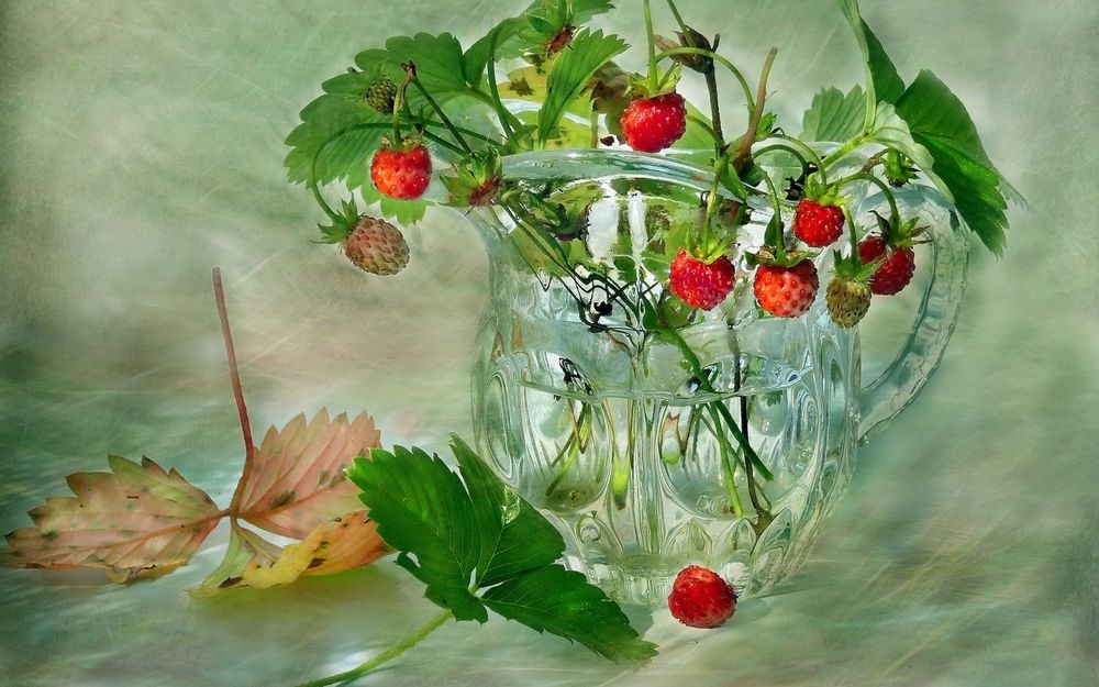 Обои для рабочего стола Земляника, ягоды и листья в стеклянном кувшине и рядом, натюрморт