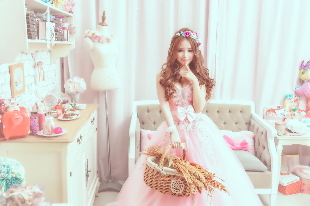 Обои для рабочего стола Азиатка в венке и бальном розовом платье с корзинкой в руке, стоит по средине своей комнаты