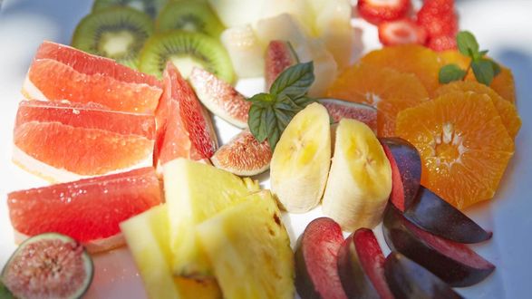 Обои на рабочий стол Свеженарезаные кусочки ананаса, апельсина, грейпфрута, банана, инжира, киви и сливы