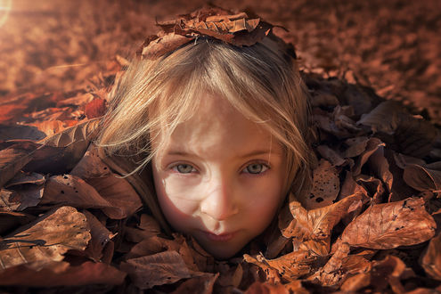 Обои на рабочий стол Девочка под осенней листвой, фотограф John Wilhelm