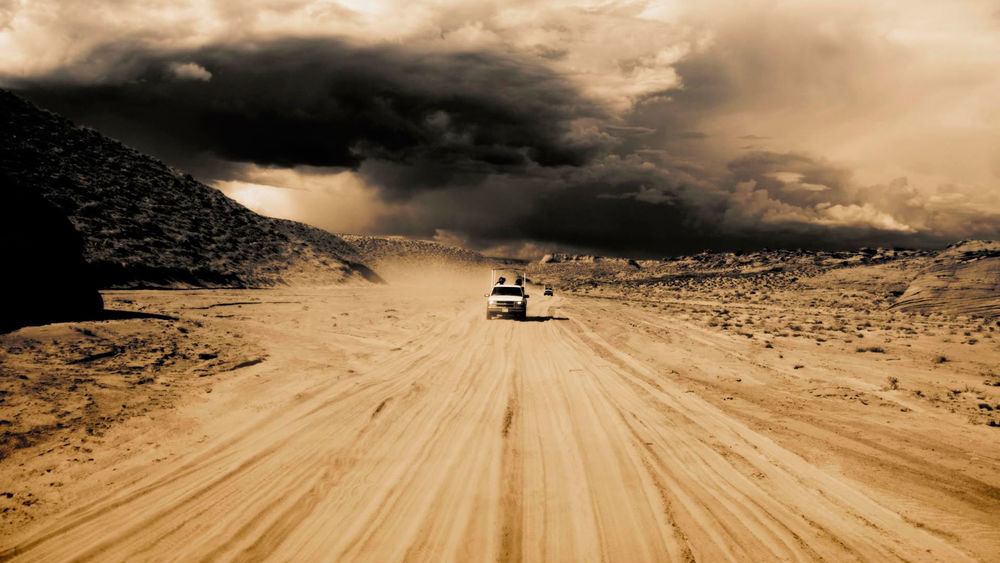 Обои для рабочего стола Одинокие путники на автомобилях на пустынной дороге