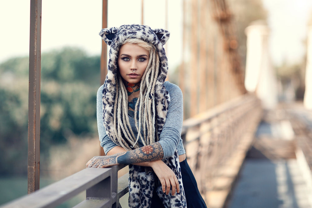 Обои для рабочего стола Девушка в шапке с ушами, с дредами, пирсингом и татуировками, стоит на мосту, Alessandro Di Cicco photoghaphy