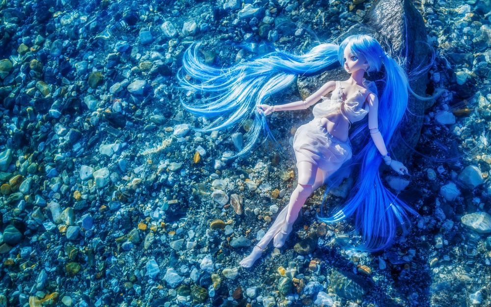 Обои для рабочего стола Кукла Hatsune Miku / Хатсуне Мику лежит на камнях
