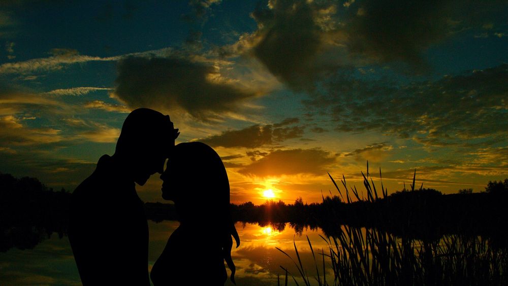 Обои для рабочего стола Пара влюбленных у озера, на фоне неба во время заката солнца, by Cocoparisien