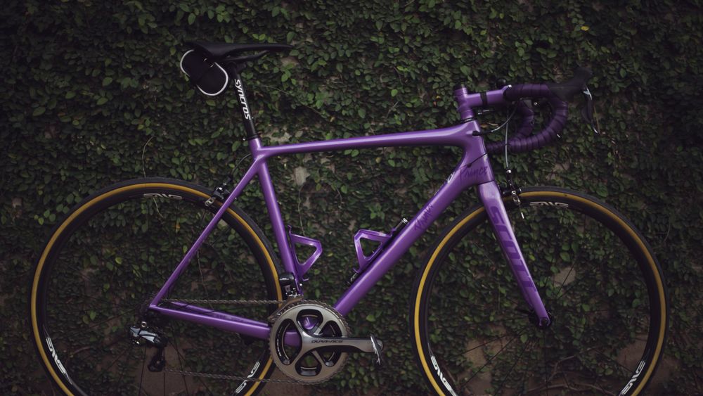 Обои для рабочего стола Фиолетовый велосипед на фоне зеленой стены