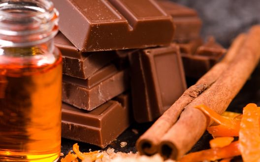 Обои на рабочий стол Плитки шоколада рядом с банкой меда и палочкой корицы