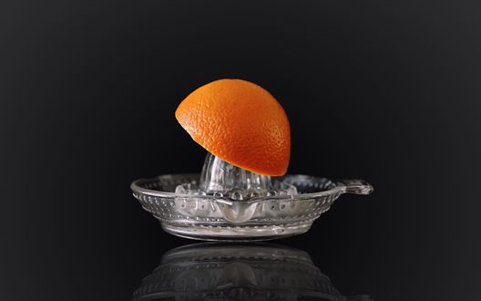Обои на рабочий стол Прозрачная соковыжималка и половинка апельсина