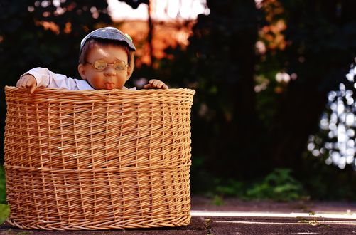 Обои на рабочий стол Игрушечная кукла мальчика в плетеной корзине