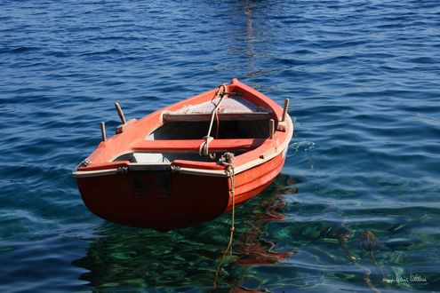Обои на рабочий стол Лодка качается на прозрачной чистой воде