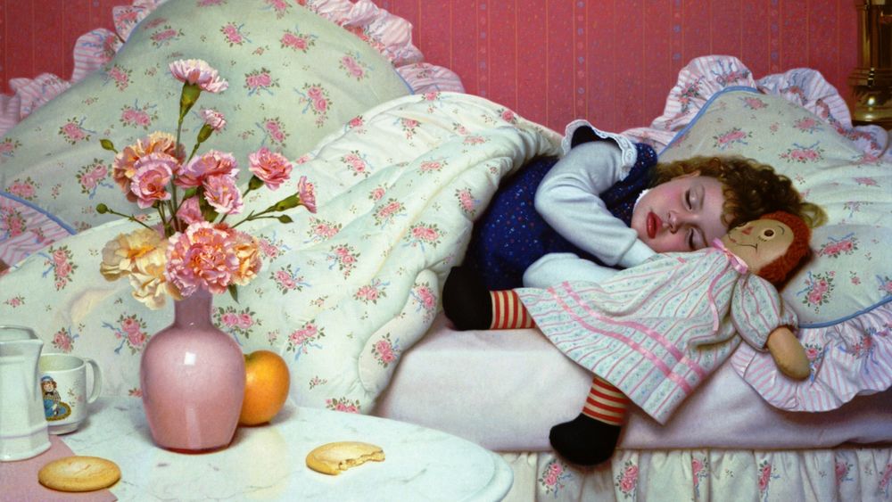 Обои для рабочего стола Маленькая девочка спит в уютной кроватке, рядом любимая игрушка, возле кроватки на тумбочке букет гвоздик в вазе и угощения, by Stephen Gjertson