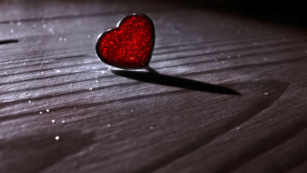 Обои для рабочего стола Красное сердечко в блестках лежит на деревянной доске