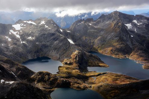 Обои на рабочий стол Вид на горы в облаках, между которыми озера, Norway / Норвегия
