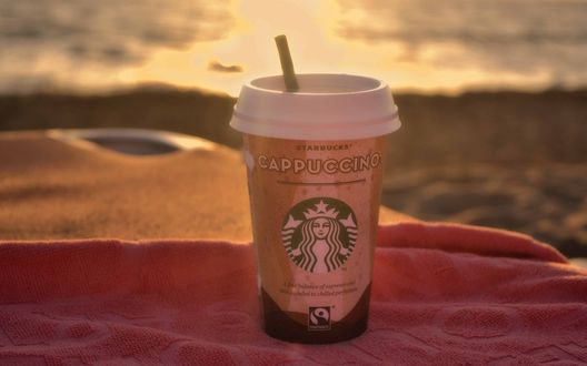 Обои на рабочий стол Стакан с кофе Starbucks Coffee / Старбакс и трубочкой стоит на полотенце (Cappuccino / Каппучино)
