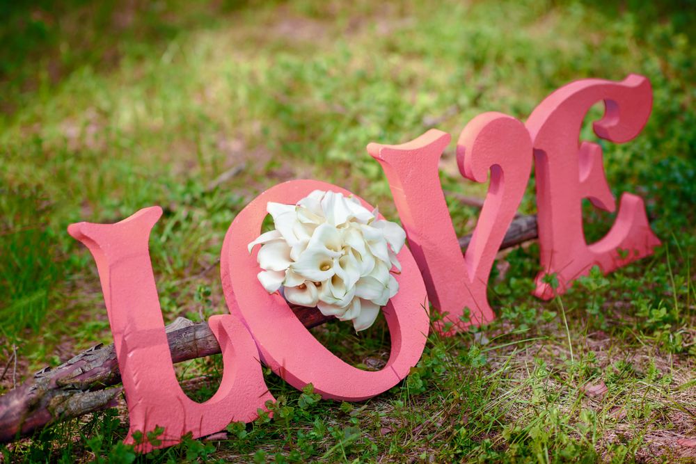 Обои для рабочего стола Надпись LOVE / любовь / из розовых букв с букетом белых каллов на траве