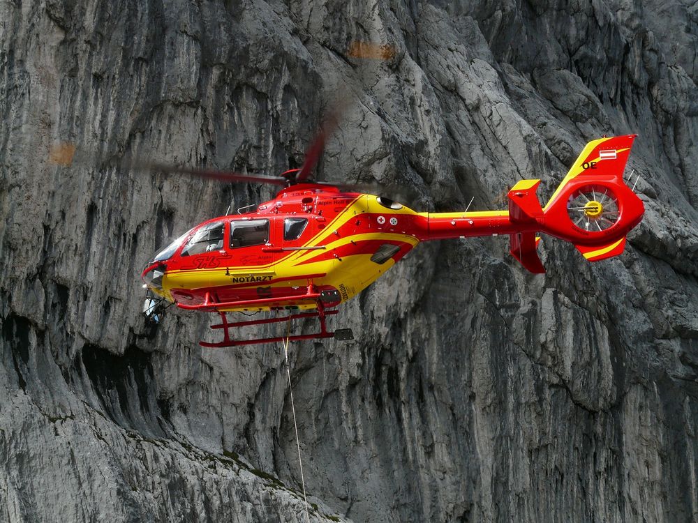 Обои для рабочего стола Спасательный красно-желтый вертолет на фоне гор