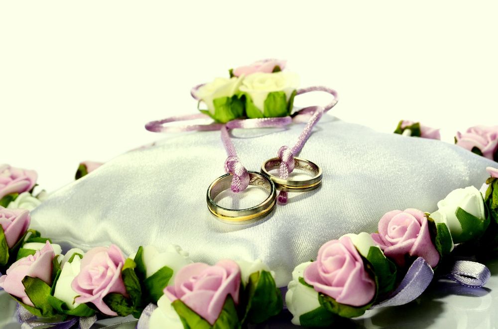 Обои для рабочего стола Два обручальных кольца на подушечке с розами
