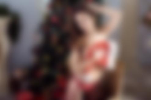 Обои на рабочий стол Девушка - брюнетка в кружевном красном белье с новогодним колпаком в руке стоит на фоне елки, фотограф Galina Tcivina