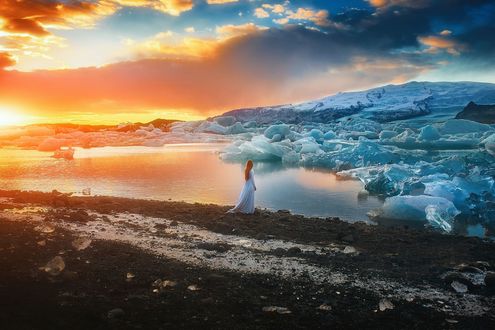 Обои на рабочий стол Девушка в длинном платье стоит у воды со льдами, фотограф TJ Drysdale