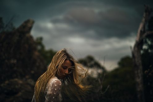Обои на рабочий стол Девушка стоит на фоне мрачного неба, фотограф Dean Raphael