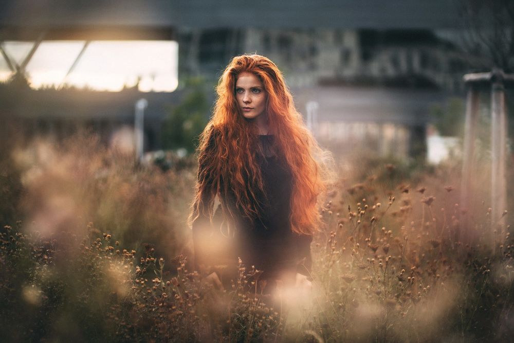 Обои для рабочего стола Рыжеволосая девушка с длинными волосам стоит в высокой траве, фотограф Martin K&;hn
