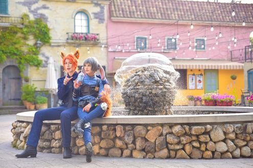 Обои на рабочий стол Косплей Judy Hopps / Джуди Хоппс и Nick Wilde / Ник Уайлд сидят около фонтана из мультфильма Zootopia / Зверополис