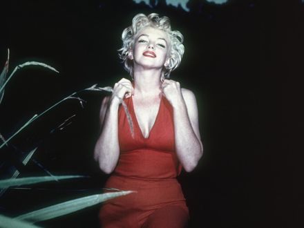 Обои на рабочий стол Marilyn Monroe / Мерилин Монро в красном открытом платье стоит на фоне черного неба