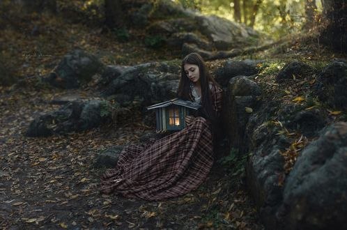 Обои на рабочий стол Девушка с домиком из книг в руках сидит на земле, фотограф Irina Dzhul