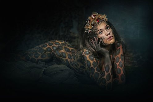 Обои на рабочий стол Девушка с рисунком кожи змеи на теле, на лице, украшением на голове лежит, держа голову руками, боди-арт от фотографа Натальи Родионовой