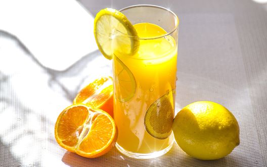 Обои на рабочий стол Стакан свежевыжатого сока лимона и апельсина